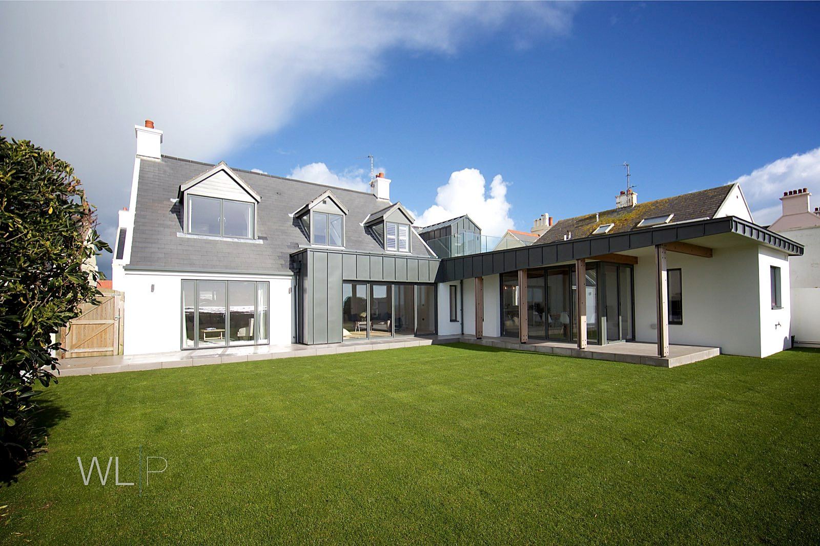 Rear extension with rendered walls, standing-seam roof and full-height glazing